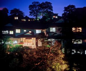 ein nachts beleuchtetes Haus mit Licht in der Unterkunft Yokikan in Ito