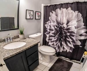 y baño con aseo y cortina de ducha. en Renovated 3 Br home near all main attractions en Kissimmee