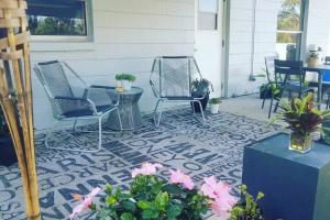 un patio con 2 sillas, una mesa y flores en Renovated 3 Br home near all main attractions en Kissimmee
