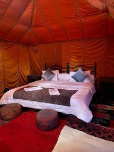 a bedroom with a bed in a tent at Dar Marhaba Merzouga in Merzouga