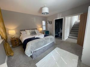 a bedroom with a bed and a staircase at Alnmouth Coastal properties close to Beach with Parking in Alnmouth