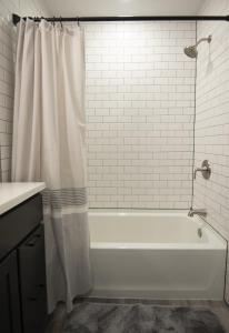 uma banheira branca com uma cortina de chuveiro na casa de banho em The Overlook at Burdett Falls em Burdett