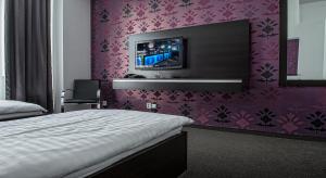 a bedroom with a bed and a tv on the wall at Hotel Polo in Prešov