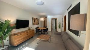 uma sala de estar com um sofá, uma televisão e uma mesa em Avenida Mare Nostrum 7 Patacona Beach Includes breakfast em Valência