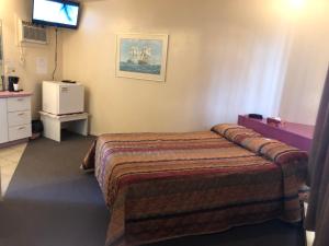 Un pat sau paturi într-o cameră la Motel Le Voyageur