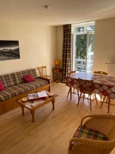 a living room with a couch and a table at Grand appartement hyper centre haut standing in La Bourboule