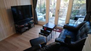uma sala de estar com um sofá e uma televisão de ecrã plano em Gäststuga i centrala Ystad em Ystad