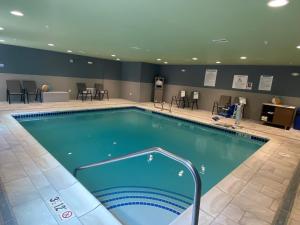 a pool in a hotel room with tables and chairs at Holiday Inn Express & Suites - Camas, an IHG Hotel in Camas