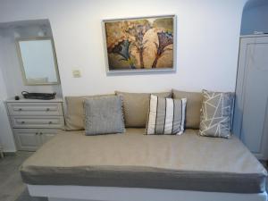 a couch with pillows on it in a room at Yposkafo Suites - Studio - Santorini in Fira
