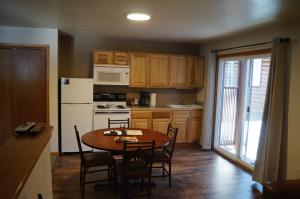 a kitchen with a table and a refrigerator and a table and chairs at Swiftcurrent Lodge in Estes Park