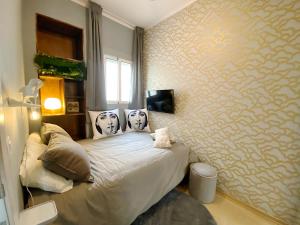 a bedroom with a bed with two faces on the pillows at Abbott apartment - 1 min from the beach - 100m2 - sleeps 8 in Sitges