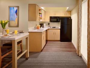 a kitchen with a table and a black refrigerator at Sonesta ES Suites Somerset in Somerset