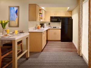 a kitchen with a table and a black refrigerator at Sonesta ES Suites Somerset in Somerset