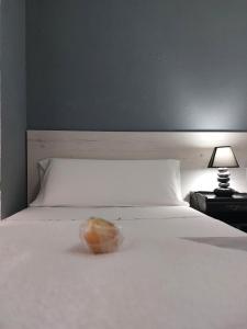 a donut sitting on top of a white bed at Pensión Saint Mateo in Logroño