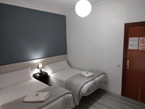 a bedroom with two beds with towels on them at Pensión Saint Mateo in Logroño