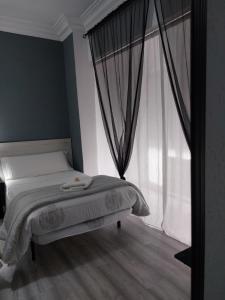 a bedroom with a bed and a large window at Pensión Saint Mateo in Logroño