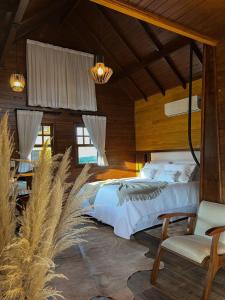 a bedroom with a bed and a table and chairs at Chão de Estrelas Cabanas in Urubici