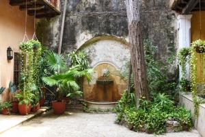 um pátio com plantas e uma parede de pedra em Casa Baloco By Soho em Cartagena das Índias