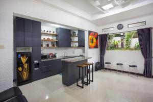 a kitchen with blue cabinets and bar stools at Villa Alessa Puncak in Puncak