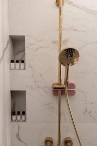 une salle de bain avec douche aux accessoires dorés dans l'établissement White House Sarajevo, à Sarajevo 73 autres photos