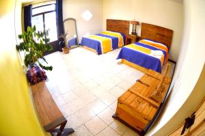 Habitación con 2 camas en una habitación en Vivir Bonito Hostal en Morelia