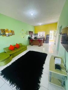 a living room with a green couch and a black rug at Spring Palm Estate in St Mary