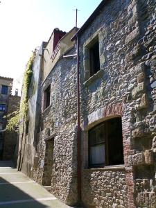 an old stone building with windows on a street at BAIX EMPORDÀ. Increíble casa en pueblo medieval in Cruïlles