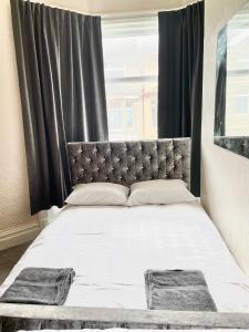 een slaapkamer met een groot bed en zwarte gordijnen bij The Stone House Hotel in Blackpool