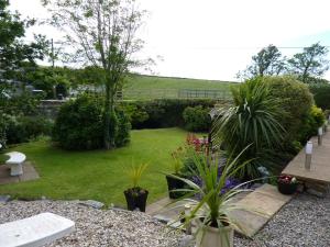 a garden with a bench and some plants at Yr Hen Felin - The Old Mill B&B in Morfa Nefyn