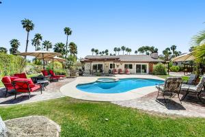 a backyard with a pool and chairs and a house at Serenity Palm Springs Ranch Permit# 2869 in Palm Springs