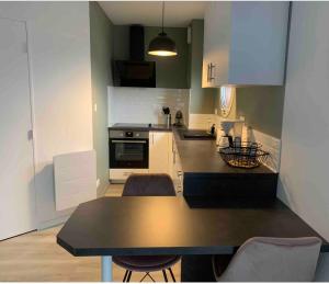 Una cocina con una mesa y algunas sillas. en Cocon à TRELAZE, en Trélazé