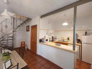 eine Küche und ein Esszimmer mit einem Tisch und einer Treppe in der Unterkunft Casa Villa El Olivar in Huelva