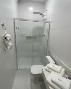 a white bathroom with a shower and a toilet at Almada Studio 77 in Cunha +14 photos