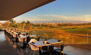 uma fila de mesas e cadeiras num restaurante em Super Apt T3 Rez de jardin Prestigia Golf Piscine em Marraquexe