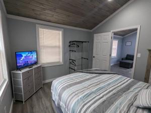 1 dormitorio con 1 cama y TV en Summerlee Suite - Beautiful Remodeled Farmhouse, en Oak Hill