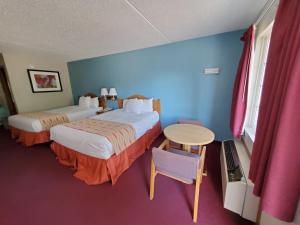 Habitación de hotel con 2 camas y mesa en Spinning Wheel Inn, en Branson
