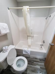 La salle de bains blanche est pourvue de toilettes et d'une baignoire. dans l'établissement Twelve Oaks Inn, à Branson
