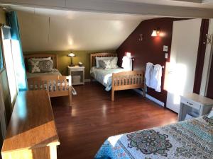 um quarto com duas camas e uma mesa em La Maison Clarence em Baie-Saint-Paul