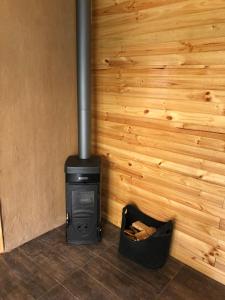 estufa negra en una habitación con pared de madera en Puma Cottage, en Horcón
