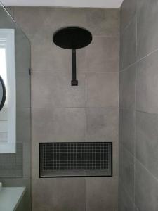 a shower with a black fan in a bathroom at Homely Getaways In Belmont in Belmont