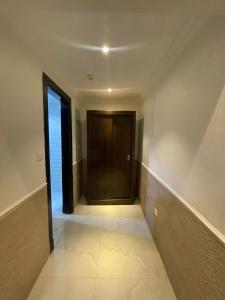 an empty hallway with a door and a staircase at رواسي الفخامة للشقق الفندقية in Taif
