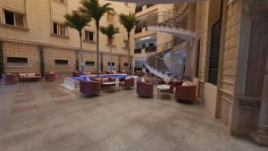 a lobby of a building with chairs and palm trees at رواسي الفخامة للشقق الفندقية in Taif