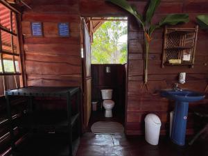 a small bathroom with a toilet and a sink at Hacienda Rio Oro in Agua Buena