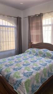 1 dormitorio con 1 cama con edredón azul y blanco en Casa Jacinto en San Juanillo