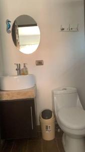 La salle de bains est pourvue de toilettes, d'un lavabo et d'un miroir. dans l'établissement Casa Jacinto, à San Juanillo