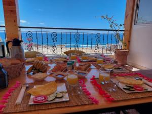 una mesa con comida y vistas a la playa en taghazout life, en Taghazout