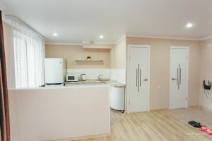 cocina con electrodomésticos blancos y encimera blanca en Уютная квартира, en Semey