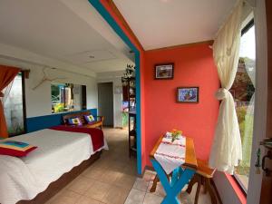 una camera da letto con pareti arancioni, un letto e un tavolo di Lidia's Mountain View Vacation Homes a Monteverde Costa Rica