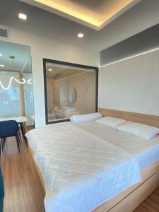 um quarto com uma grande cama branca e uma casa de banho em FLC Sea Tower Quy Nhơn - VIP HOUSE em Quy Nhon