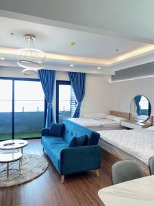 uma sala de estar com uma cama grande e um sofá azul em FLC Sea Tower Quy Nhơn - VIP HOUSE em Quy Nhon